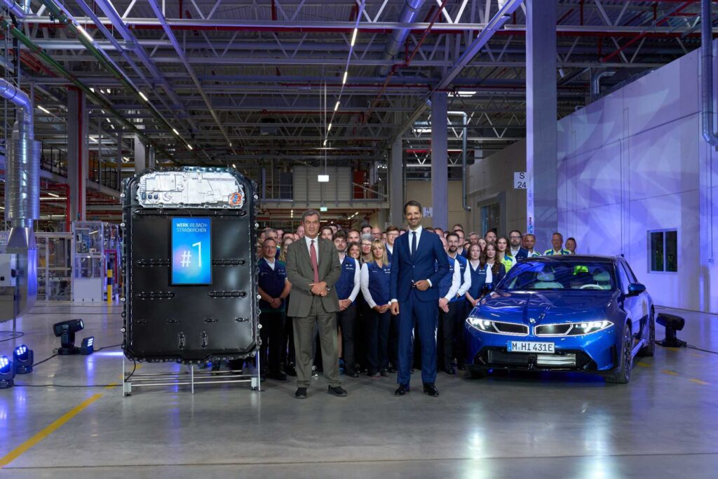 BMW Group team at the opening of Plant Irlbach-Straßkirchen with a battery pack and a blue BMW i3