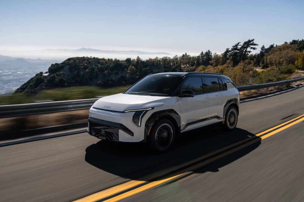 White 2027 Kia EV3 driving on a mountain road