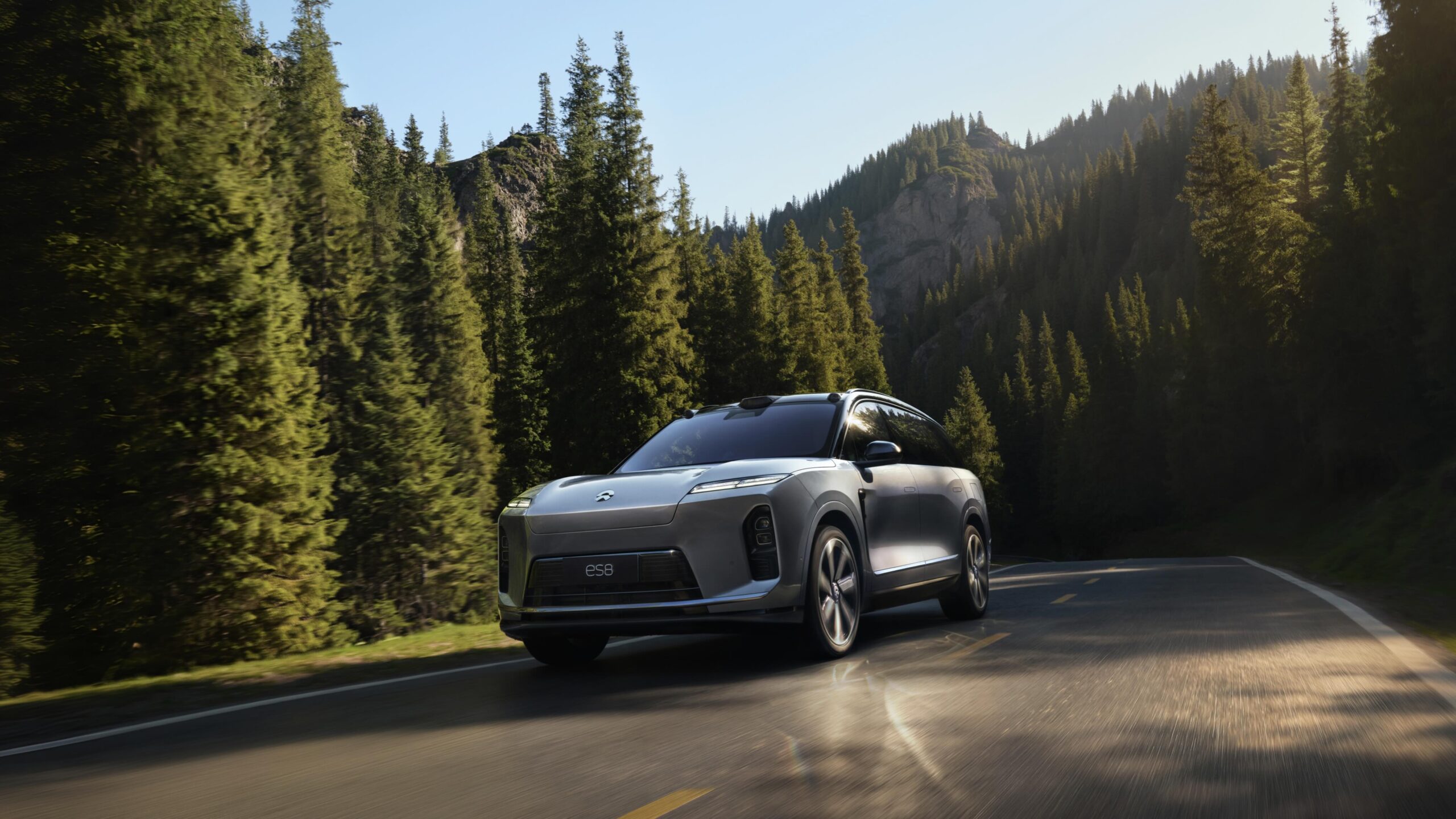 Silver NIO ES8 electric SUV driving on a mountain road