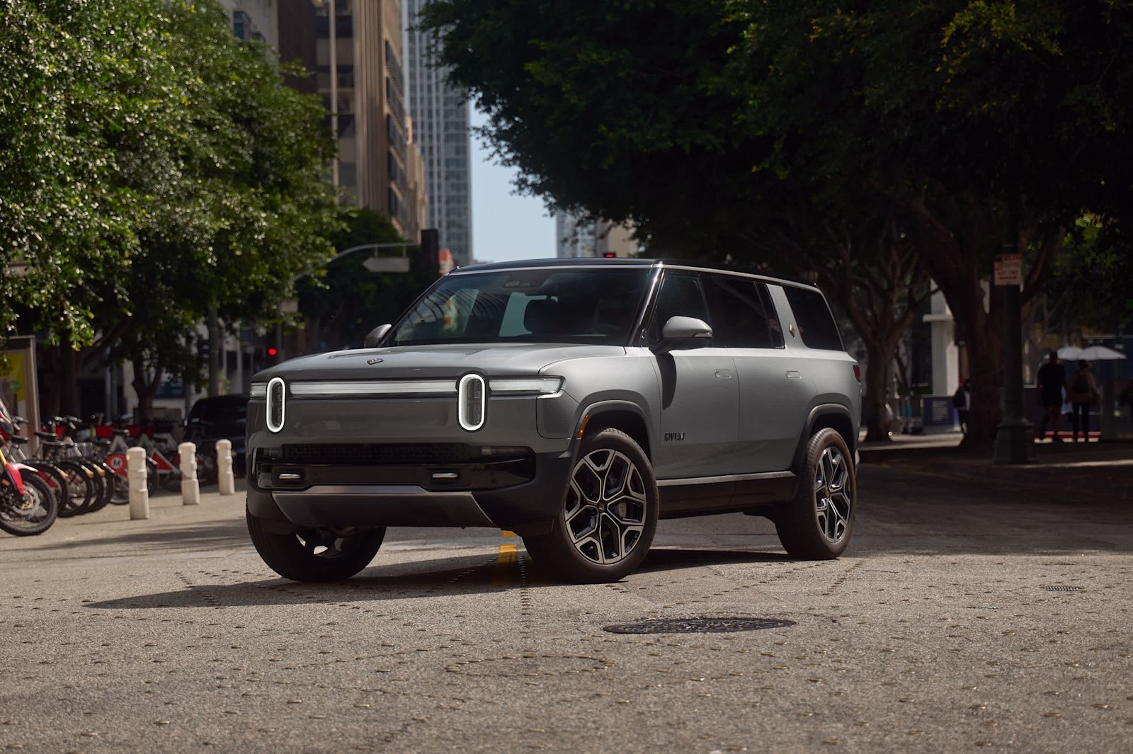 Silver Rivian R1S SUV on a city street, a Rivian photo.