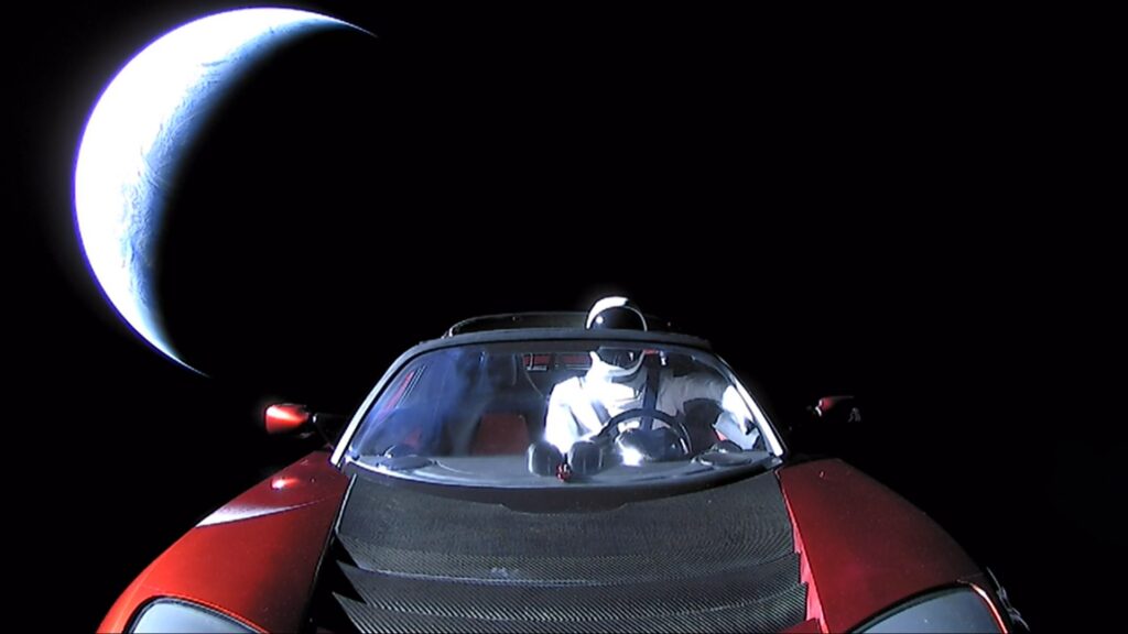 Starman sits in Elon Musk's red Tesla Roadster in space with Earth in the background after the first Falcon Heavy launch