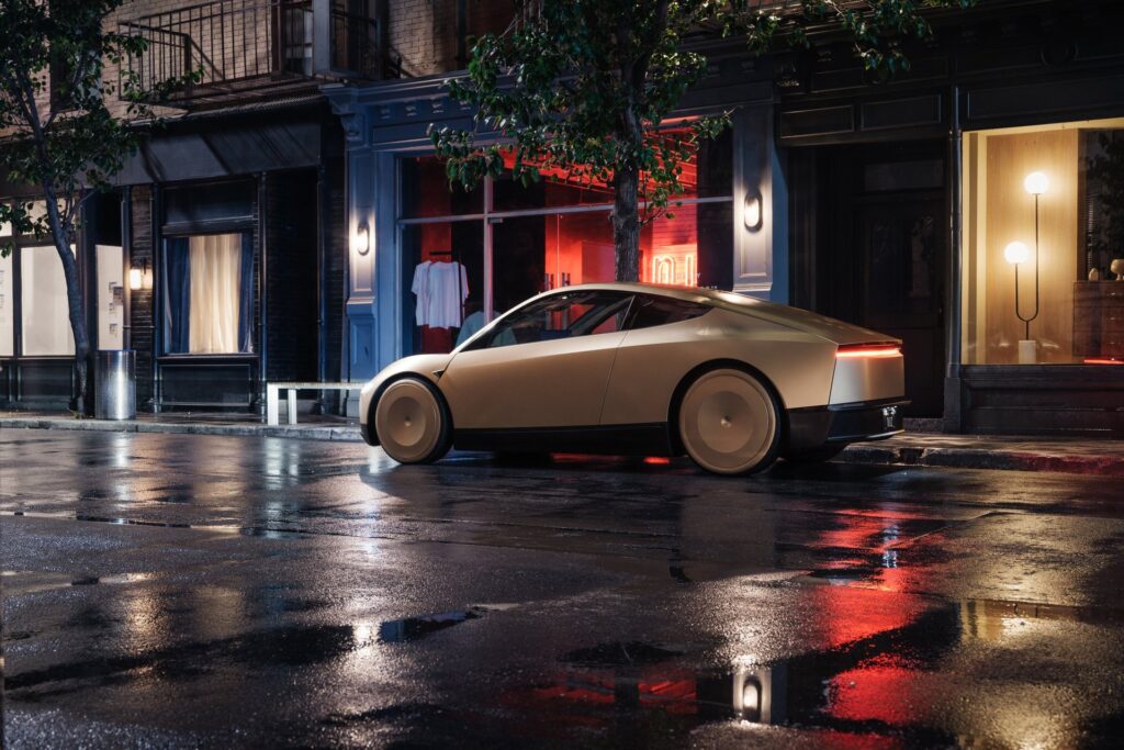 Gold Tesla Cybercab from the rear three-quarter angle on a wet street at night with its tail light on
