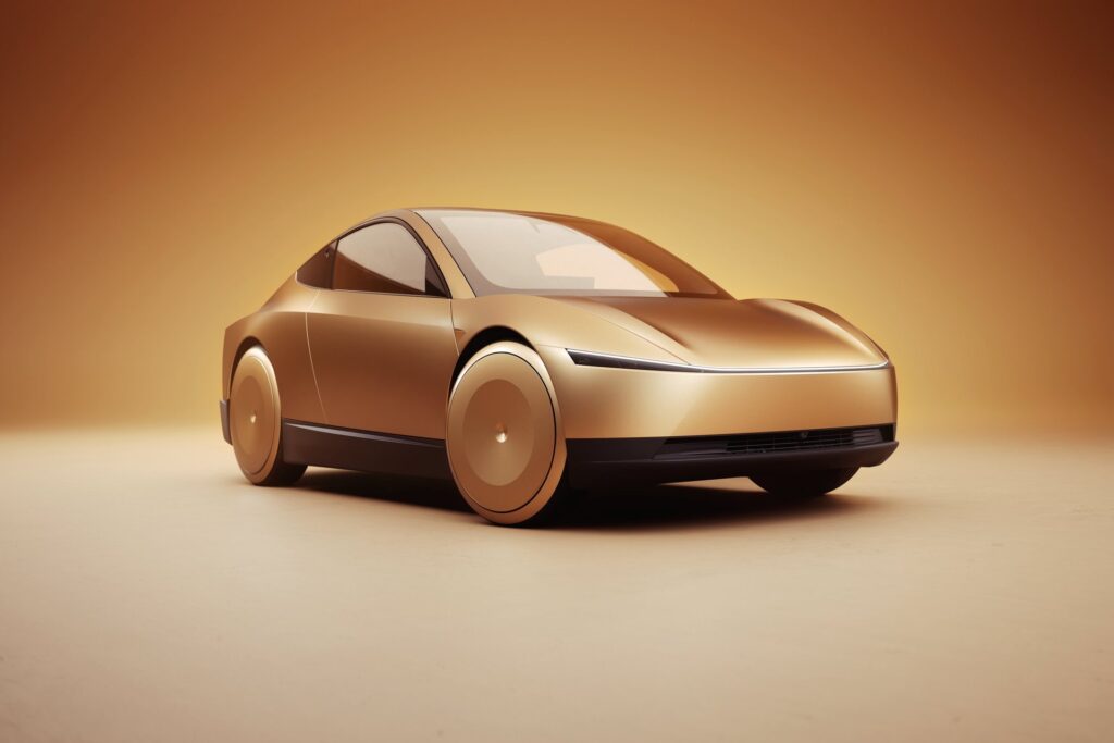 Gold Tesla Cybercab from a low front three-quarter angle in a warm studio
