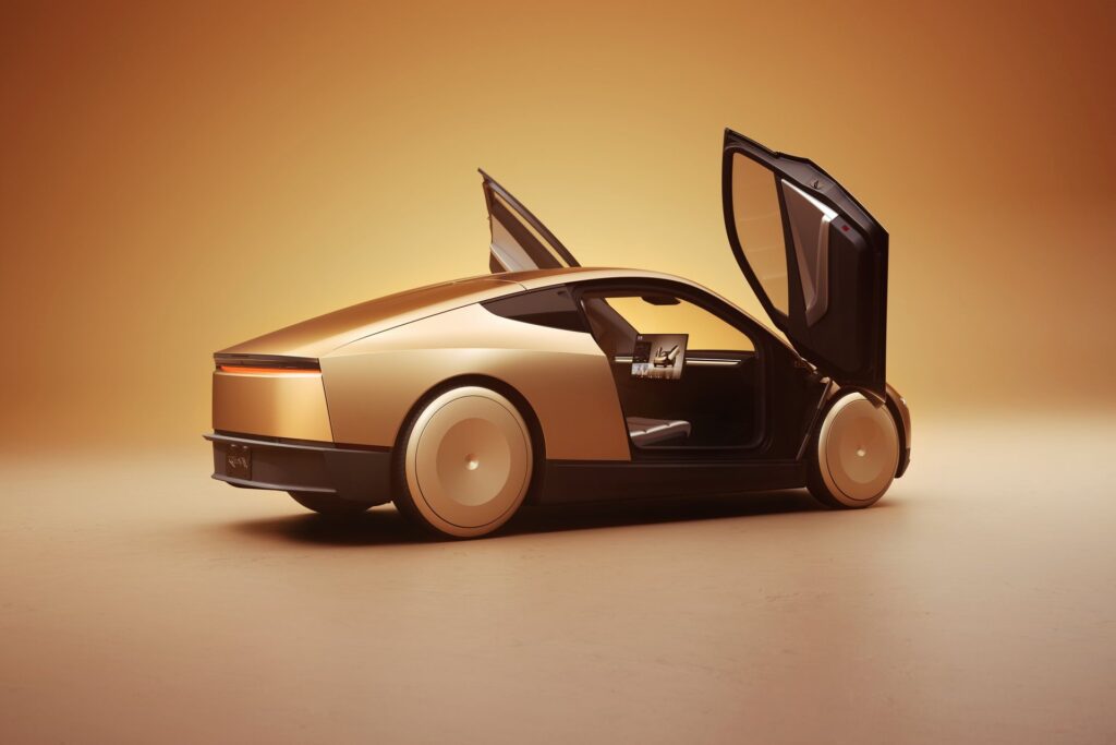 Gold Tesla Cybercab from the rear with both butterfly doors open in a studio