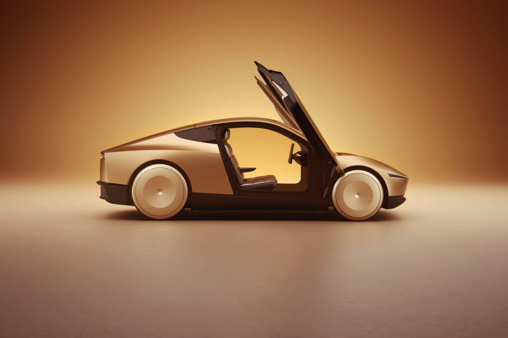 Gold Tesla Cybercab in side profile with its butterfly door raised and seats visible in a studio