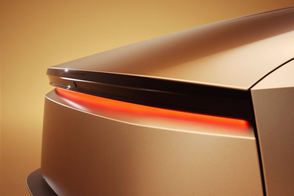 Close-up of the gold Tesla Cybercab rear corner with its glowing red light bar