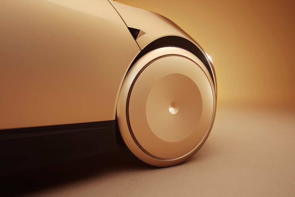Close-up of a gold Tesla Cybercab front wheel with a smooth aerodynamic cover
