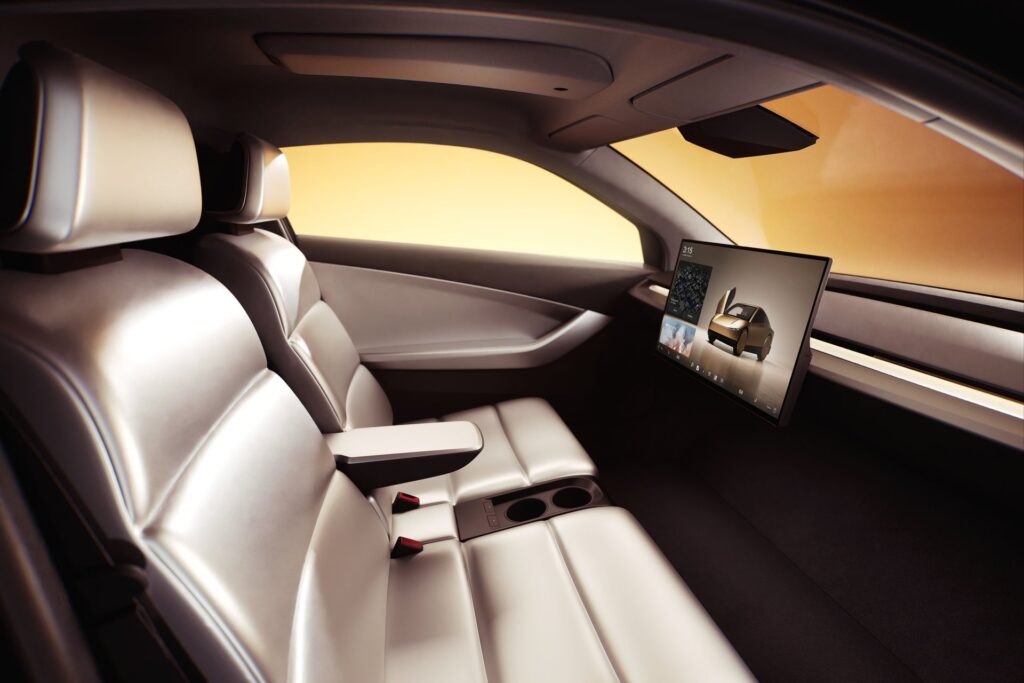 Tesla Cybercab interior with two light seats, a center armrest and a large dash-mounted screen