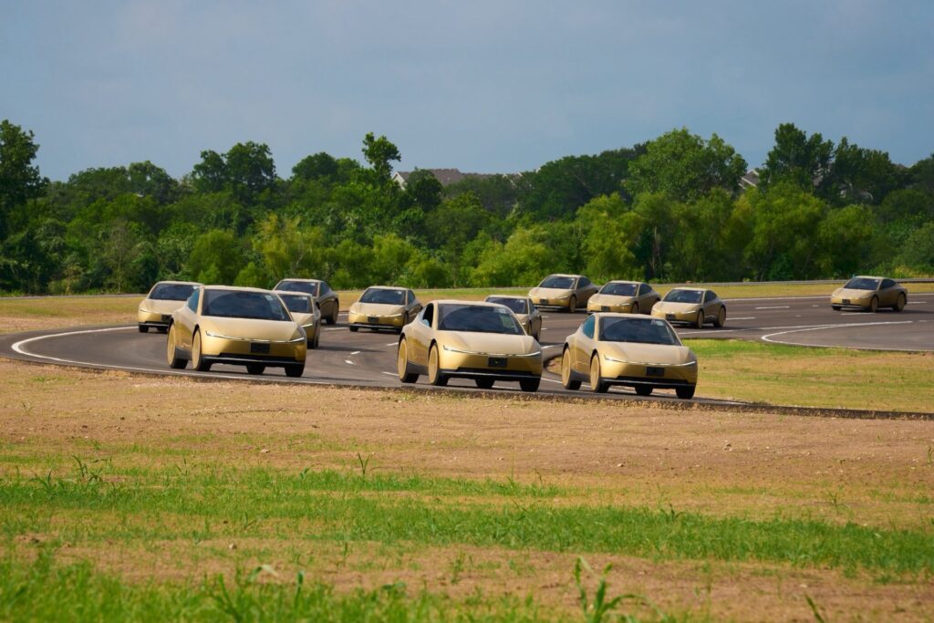 A fleet of gold Tesla Cybercabs driving on a test track