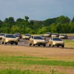 A fleet of gold Tesla Cybercabs driving on a test track