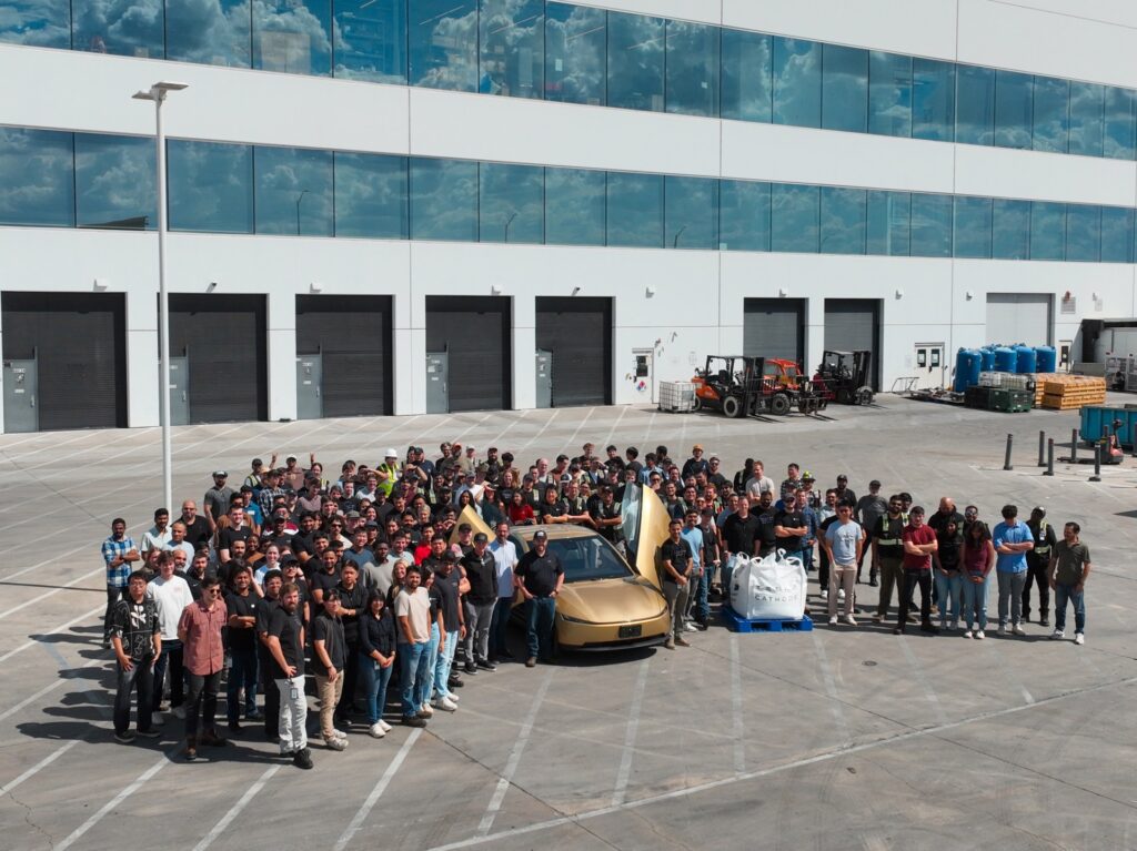 Tesla employees at Giga Texas gathered around the first Cybercab built with Tesla's in-house cathode material