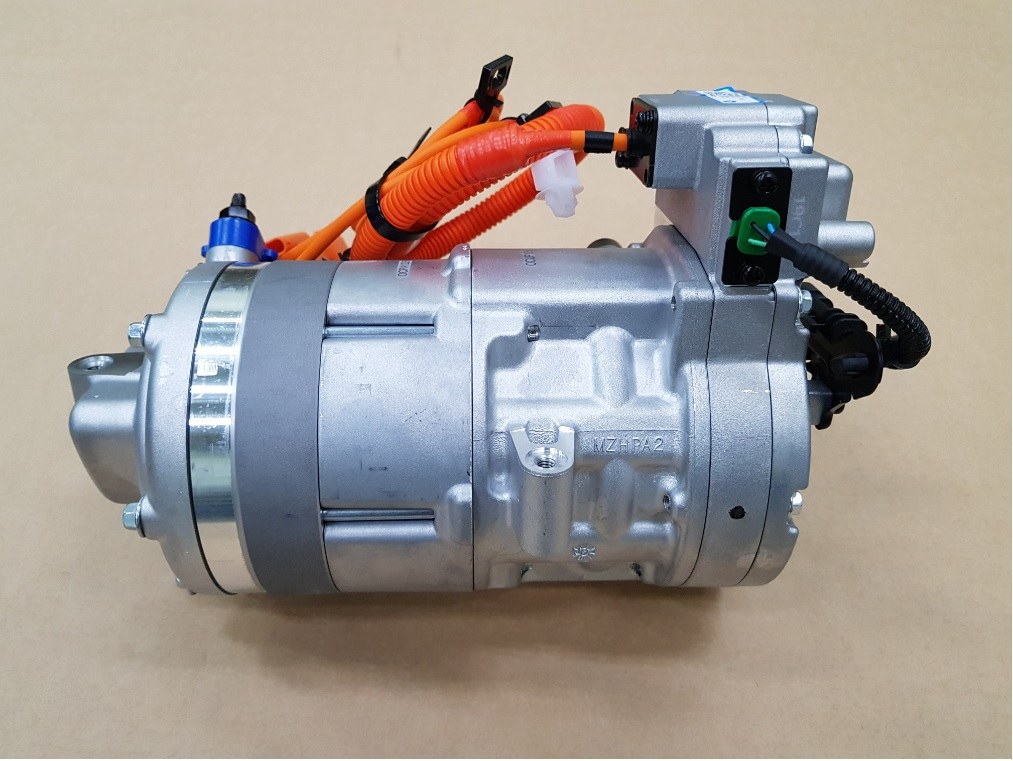 Tesla Model 3 high-voltage heat pump compressor with orange high-voltage cables