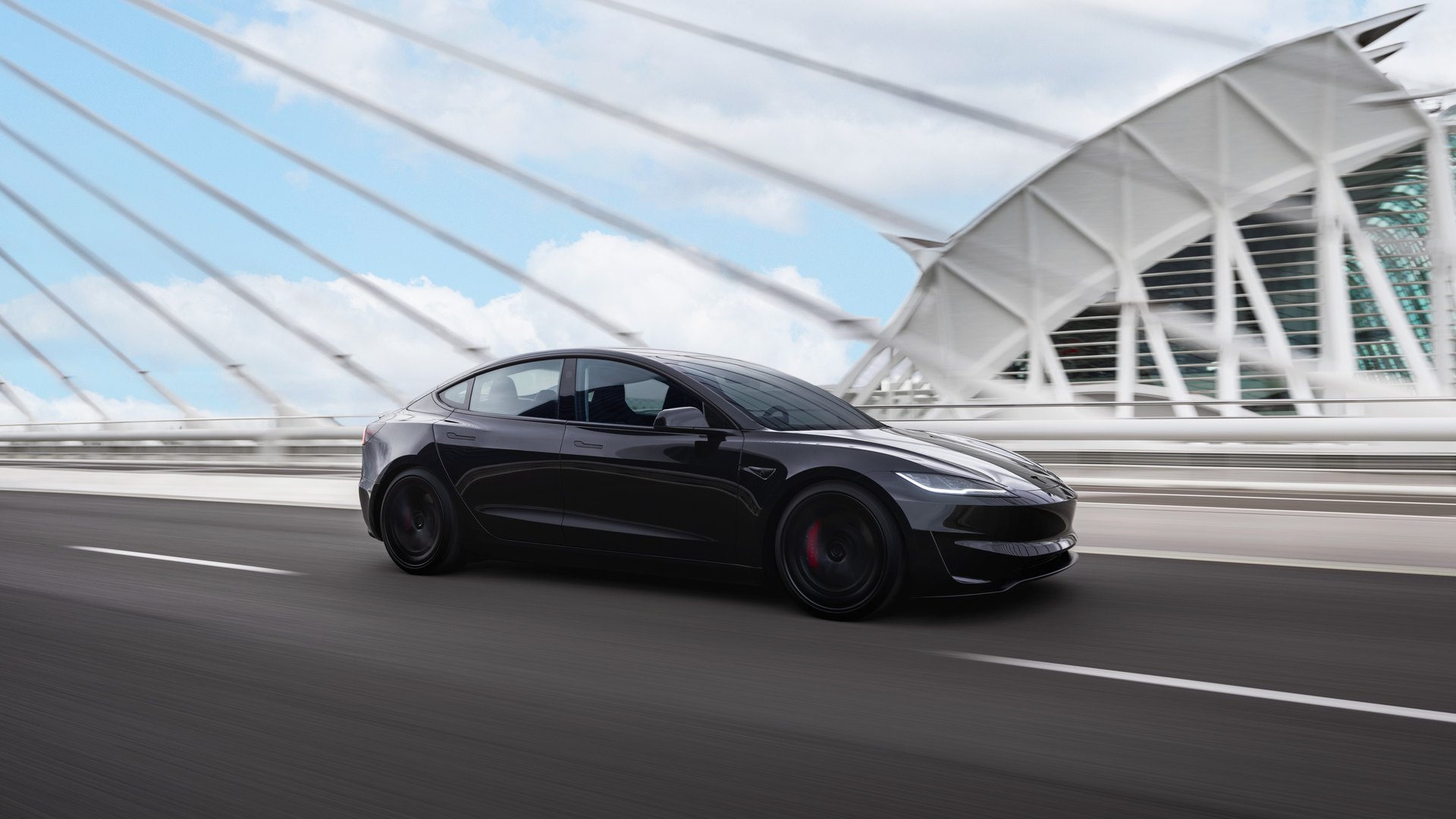 Black Tesla Model 3 Performance, an affordable driver's car today, crossing a cable-stayed bridge