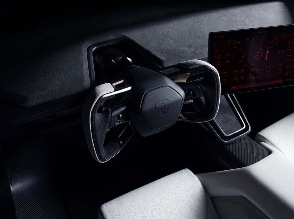 Tesla Roadster cockpit with a yoke style steering wheel and a red performance readout on the driver display