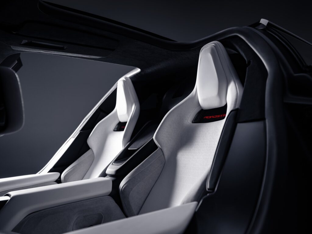 White Tesla Roadster sport seats seen through the open door, with the door frame curving overhead