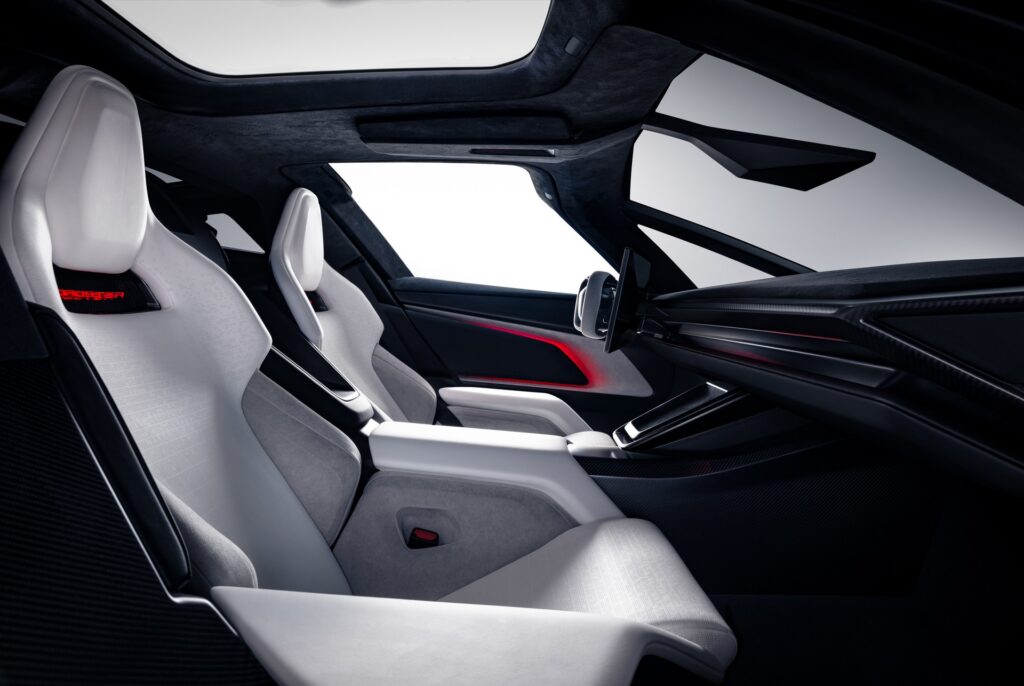 Tesla Roadster driver seat and cabin under a large glass roof, with red ambient light in the door trim