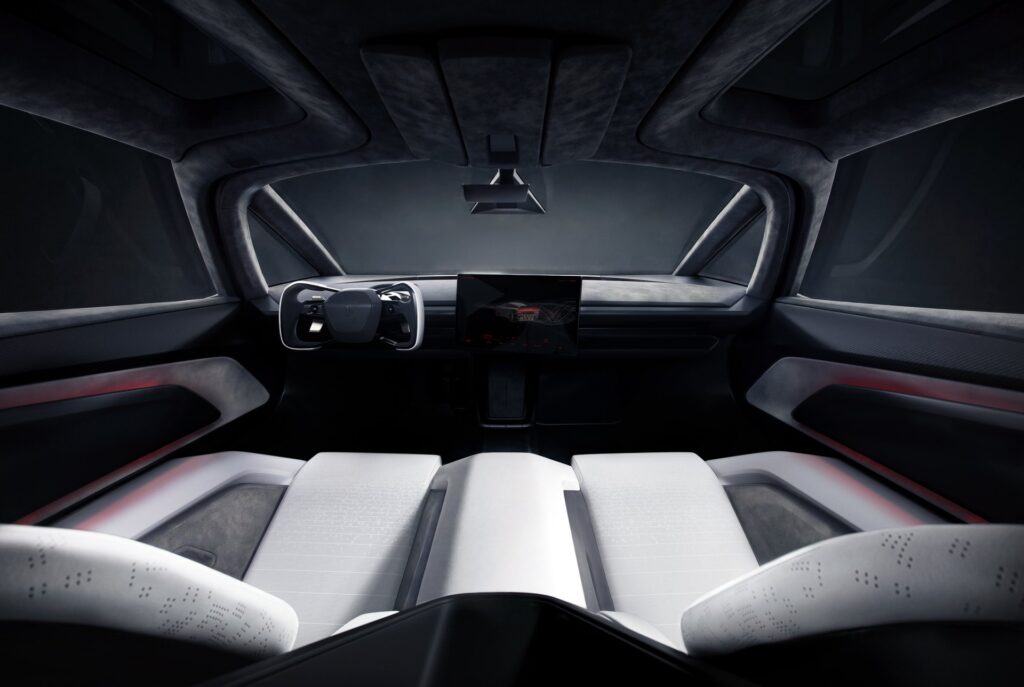 Rear view of the Tesla Roadster cabin showing four white seats facing the yoke and center display
