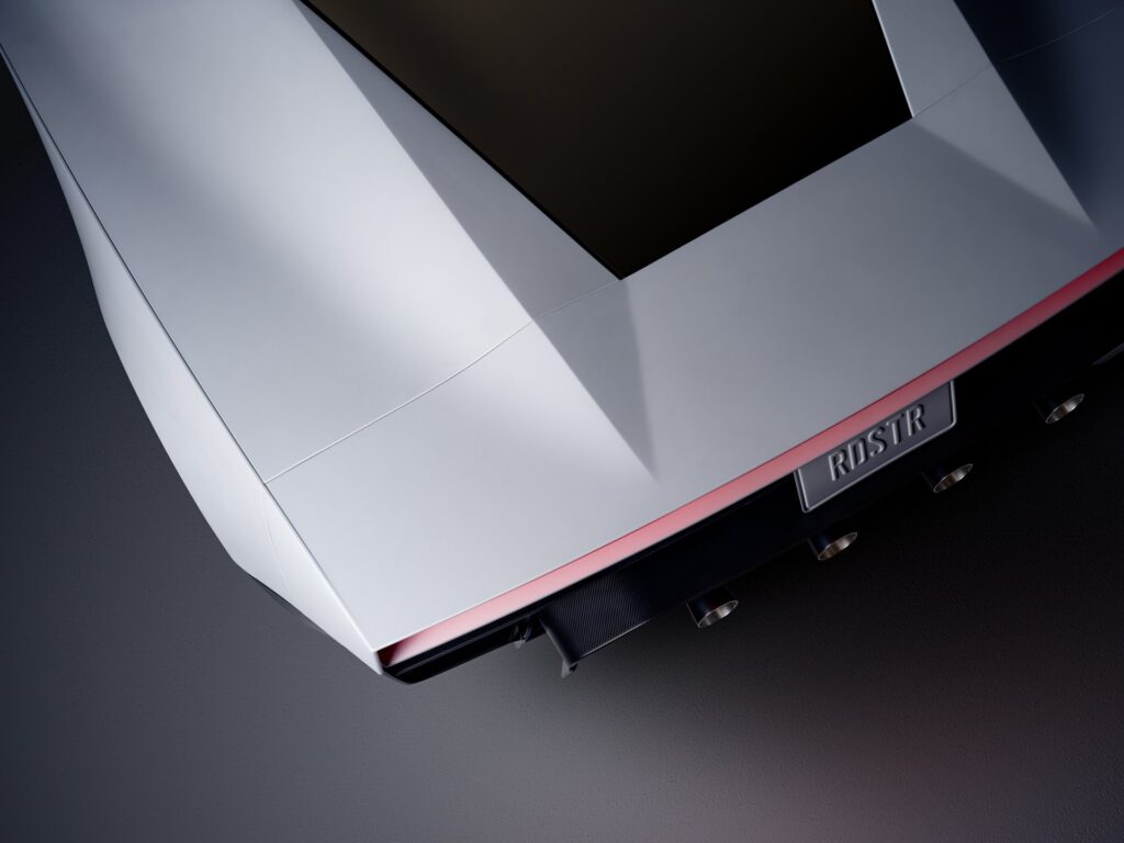 Overhead view of the Tesla Roadster's rear deck, red light strip and RDSTR plate above the thruster nozzles