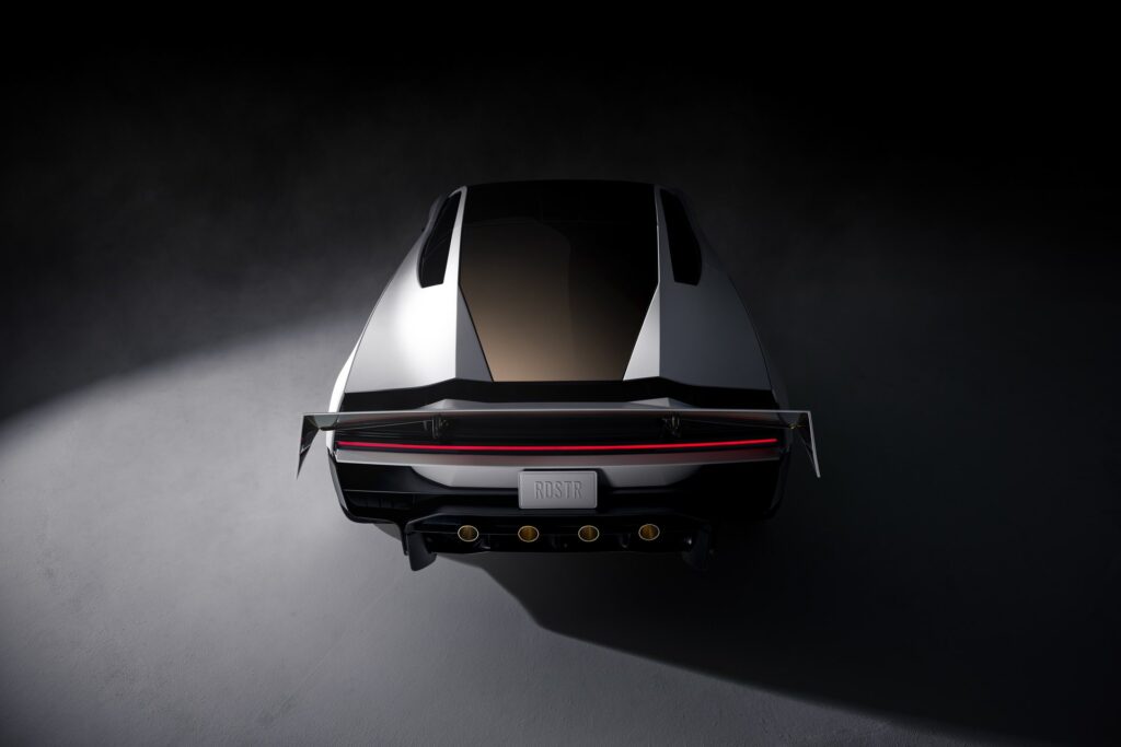Overhead rear view of a white Tesla Roadster with its wing deployed and thruster nozzles visible