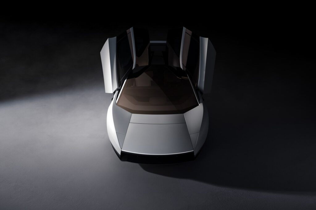 Overhead front view of a white Tesla Roadster with both doors raised