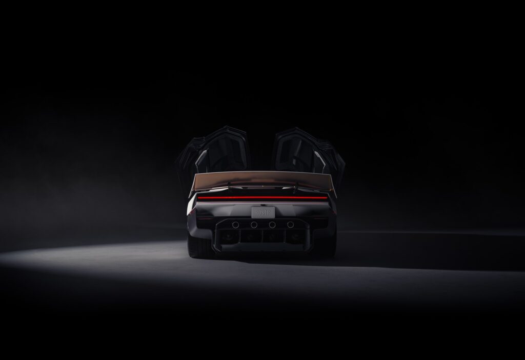 Tesla Roadster from the rear on a dark stage with both doors raised and the light bar glowing red