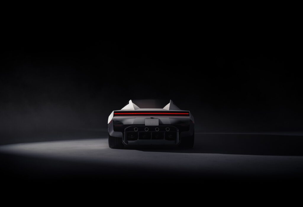 Rear view of the Tesla Roadster under a spotlight, showing its red light bar and four thruster nozzles