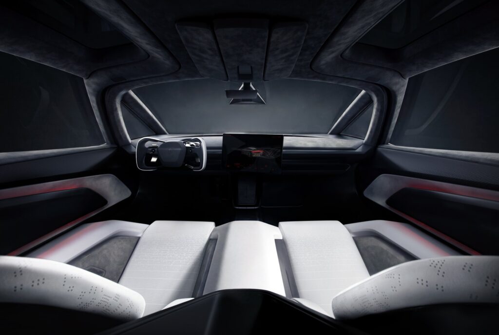 Wide view of the Tesla Roadster's white and gray microsuede cabin with a yoke and center screen
