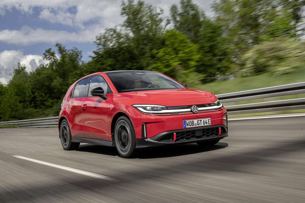 Red Volkswagen ID. Polo GTI driving on a road, front three-quarter view